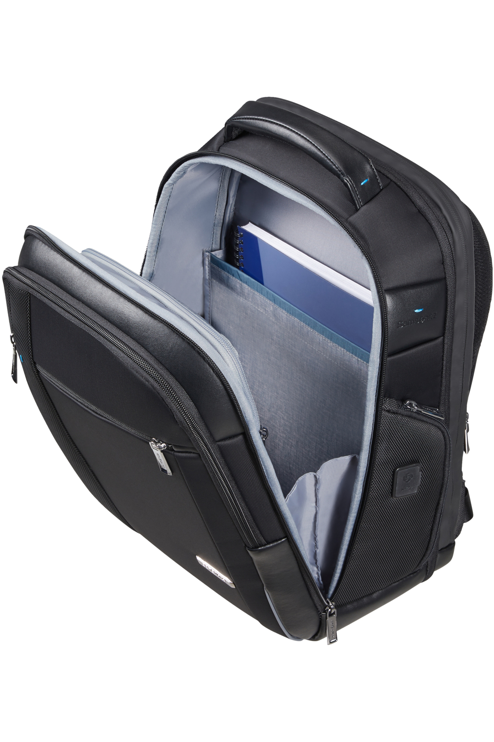 Ein schwarzer Rucksack mit geöffnetem Hauptfach und darin liegenden Notizbüchern.