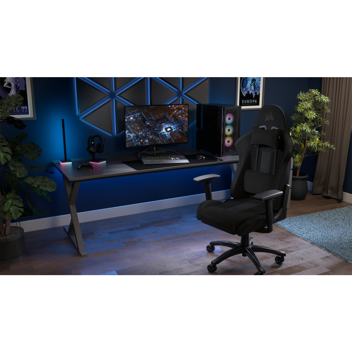 Ein schwarzer Gaming-Stuhl steht vor einem Schreibtisch mit einem Computer, Monitor und Pflanzen.