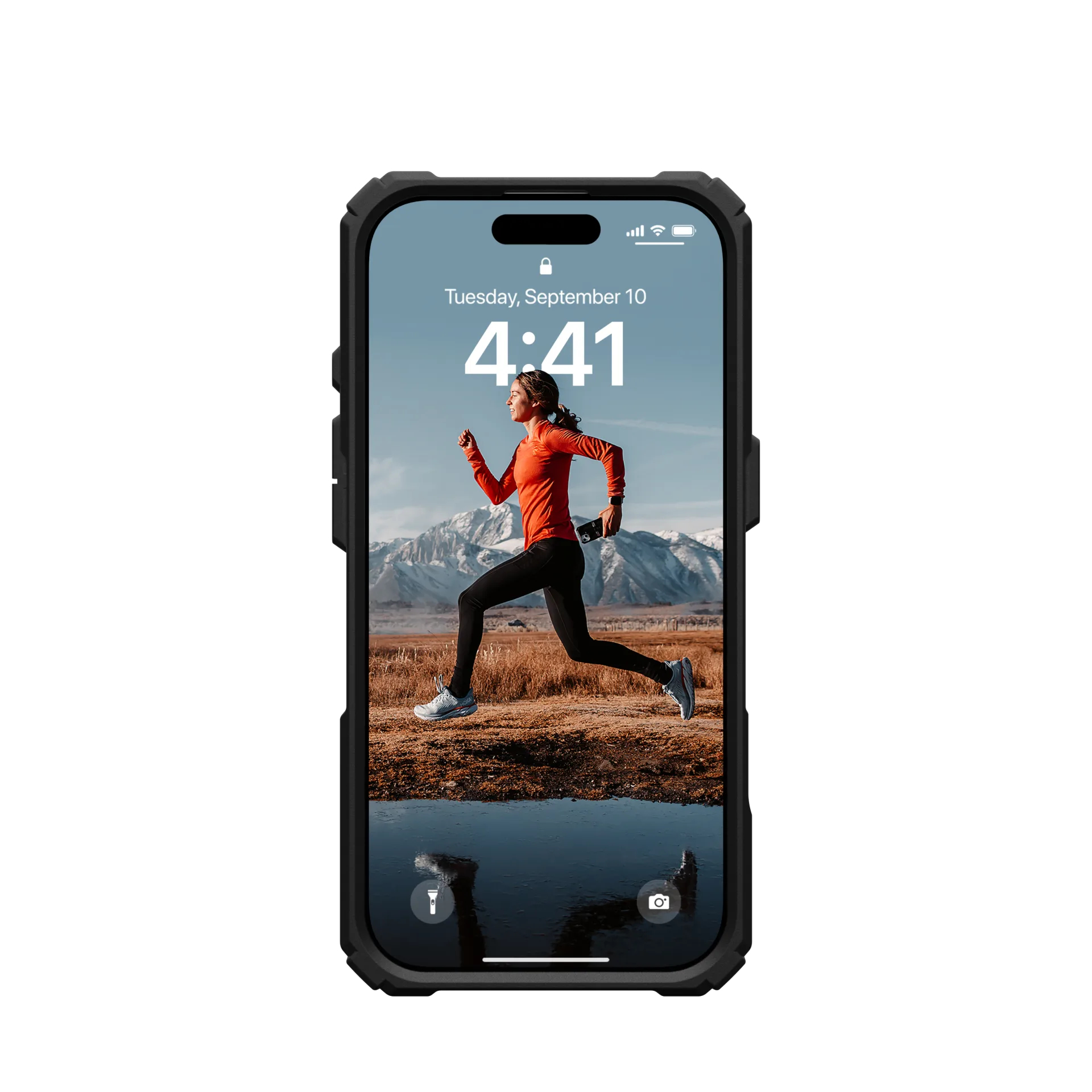 Eine Frau in orange läuft vor schneebedeckten Bergen. Auf dem Handy ist es 4:41 Uhr.