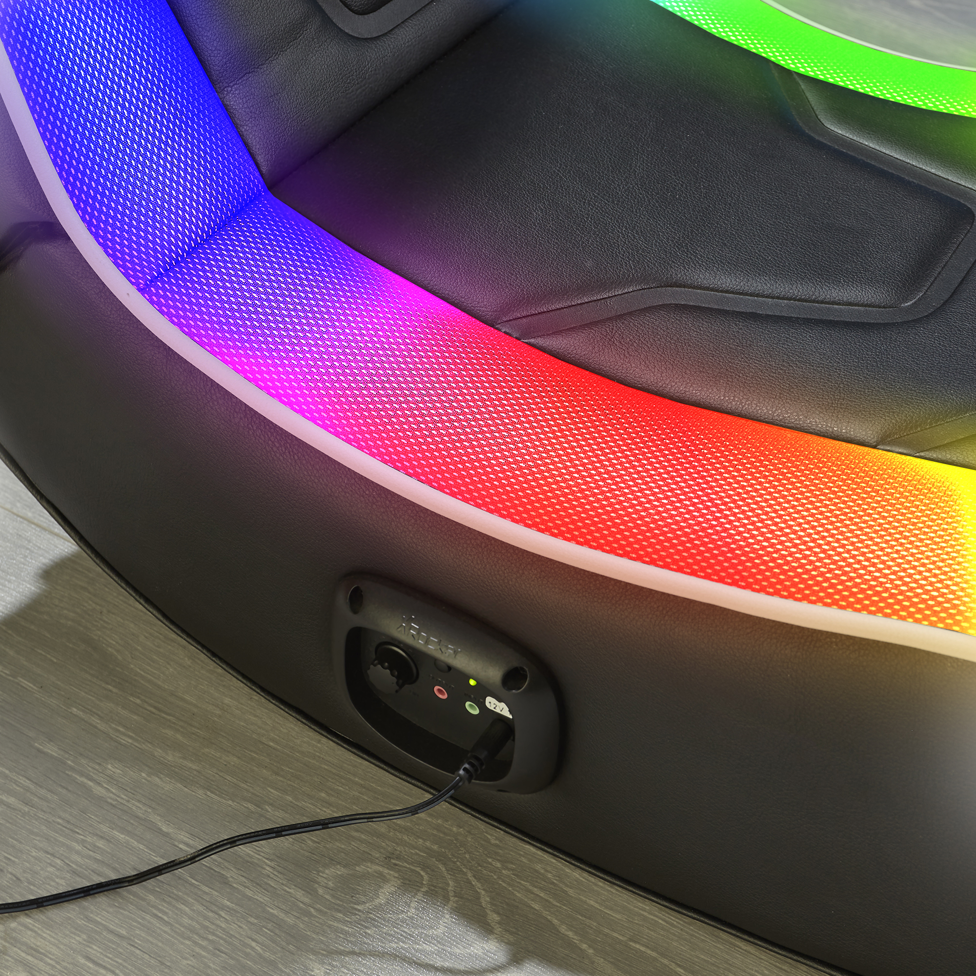 Silla gamer negra con iluminación RGB, cable y panel de control.