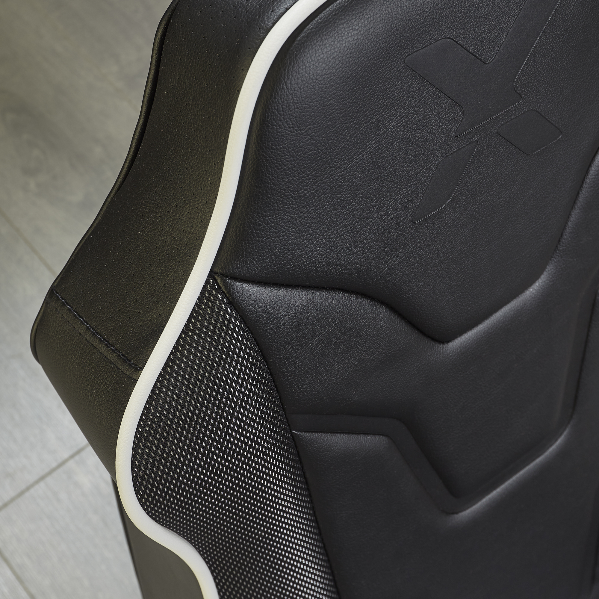Silla tapizada negra con ribete blanco y acento de fibra de carbono.