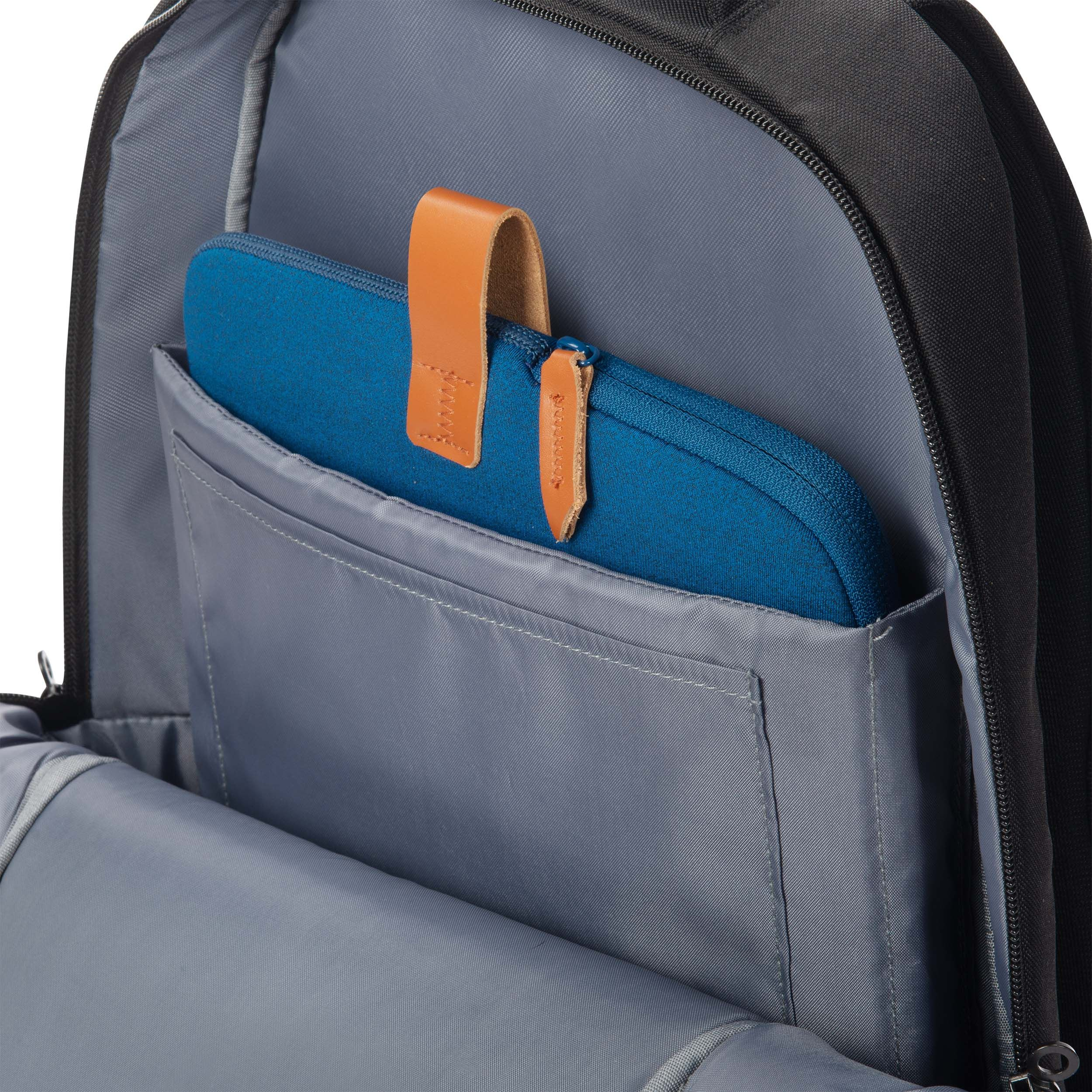 Ein blaues Etui mit Lederlaschen in einem schwarzen Rucksackfach.