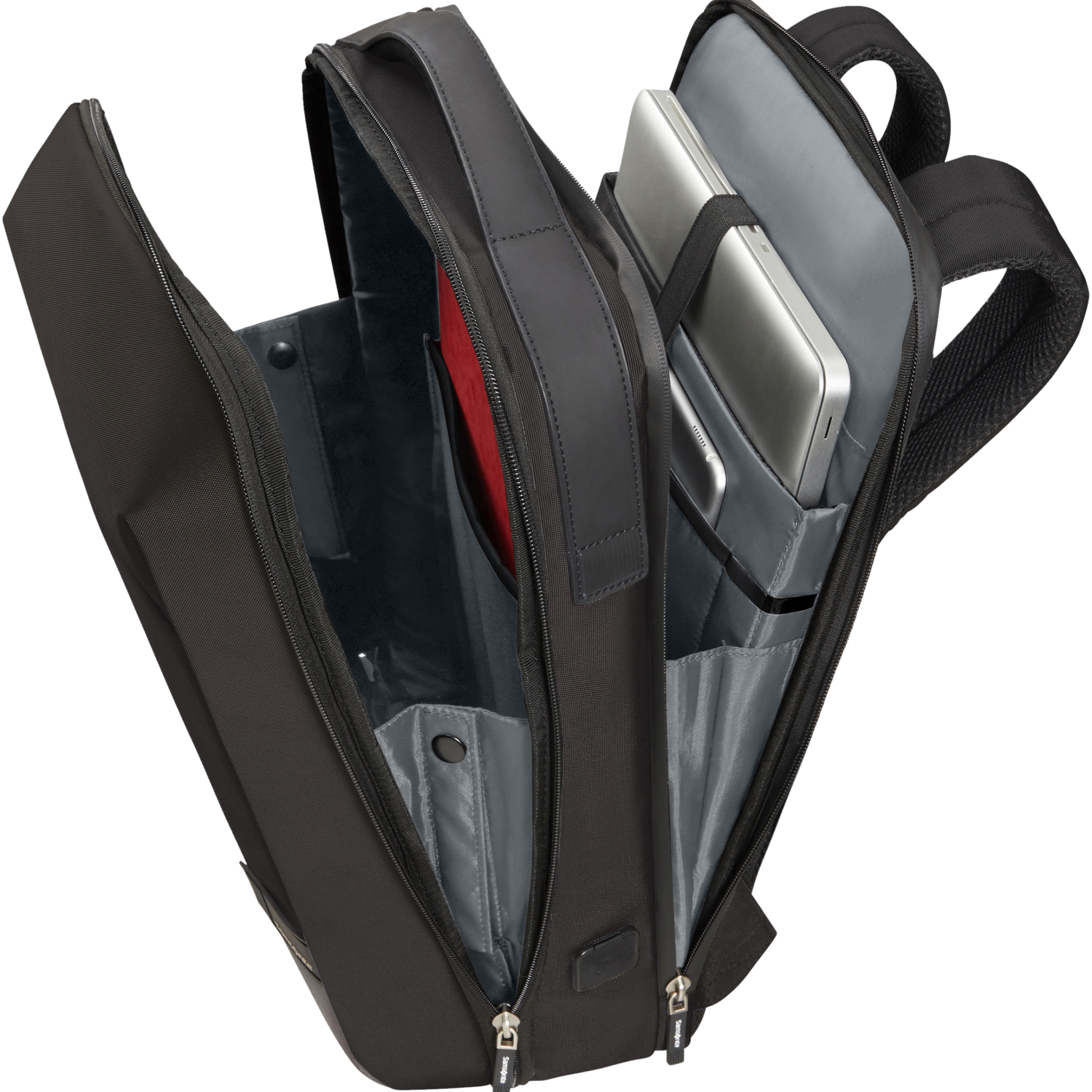 Una mochila negra con dos portátiles y un cuaderno rojo dentro.