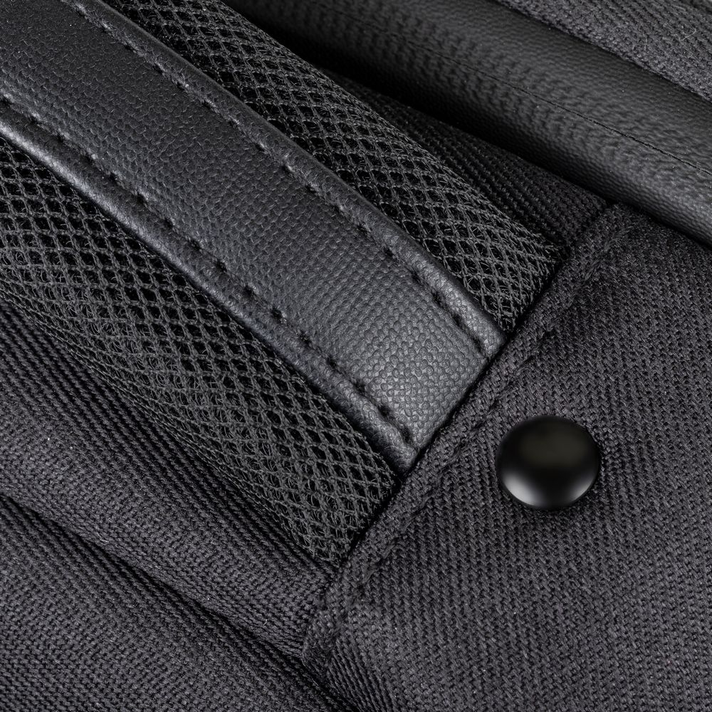 Nahaufnahme einer schwarzen Tasche mit Netzgewebe, Leder und Nahtdetails.