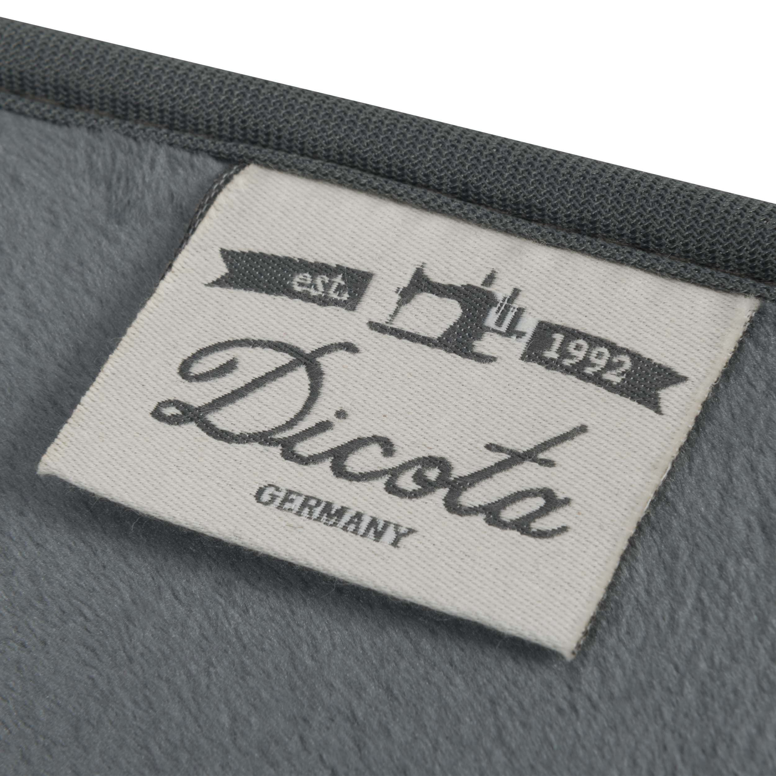 Graues Etikett mit „Dicota Germany“ und Nähmaschinen-Logo auf grauem Stoff.
