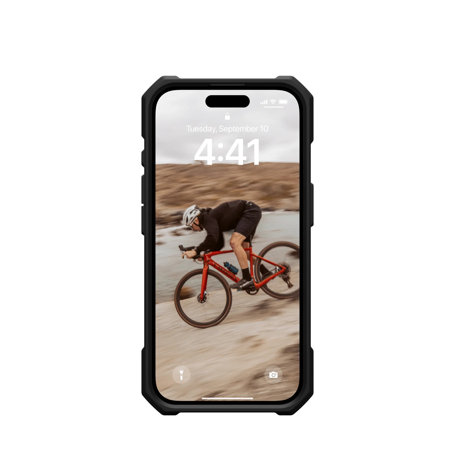 A cyclist rides a red bike on rocky terrain.