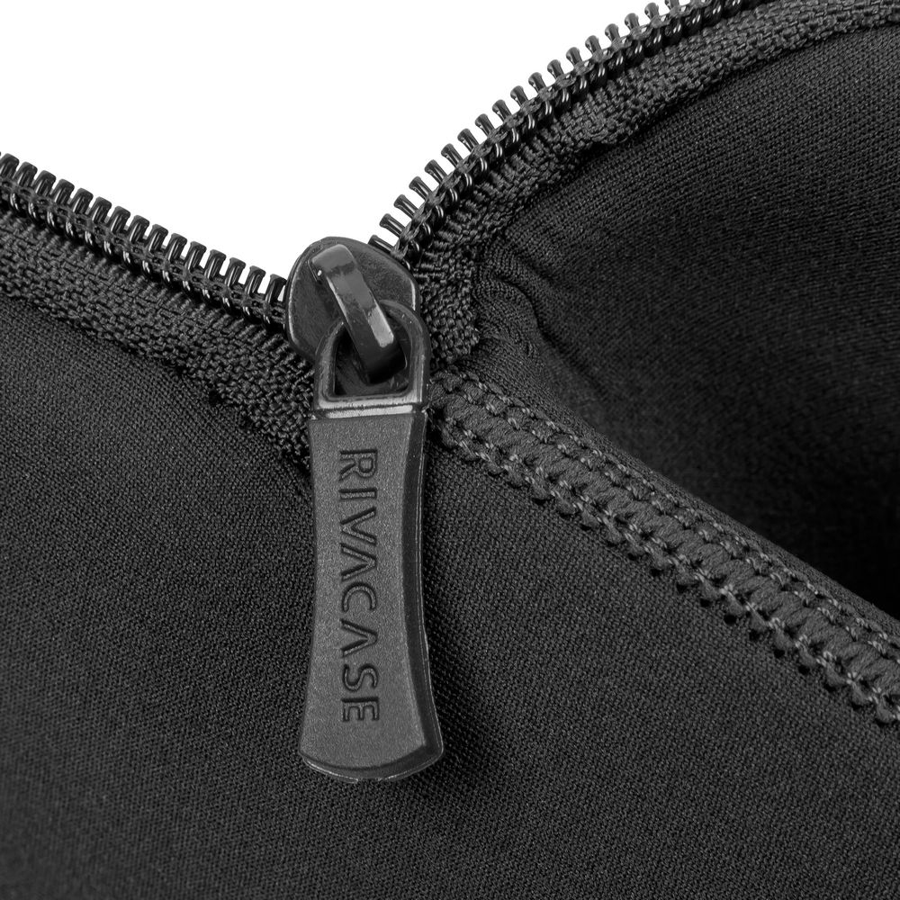 Close-up van een zwarte ritstrekker met RIVACASE-logo.