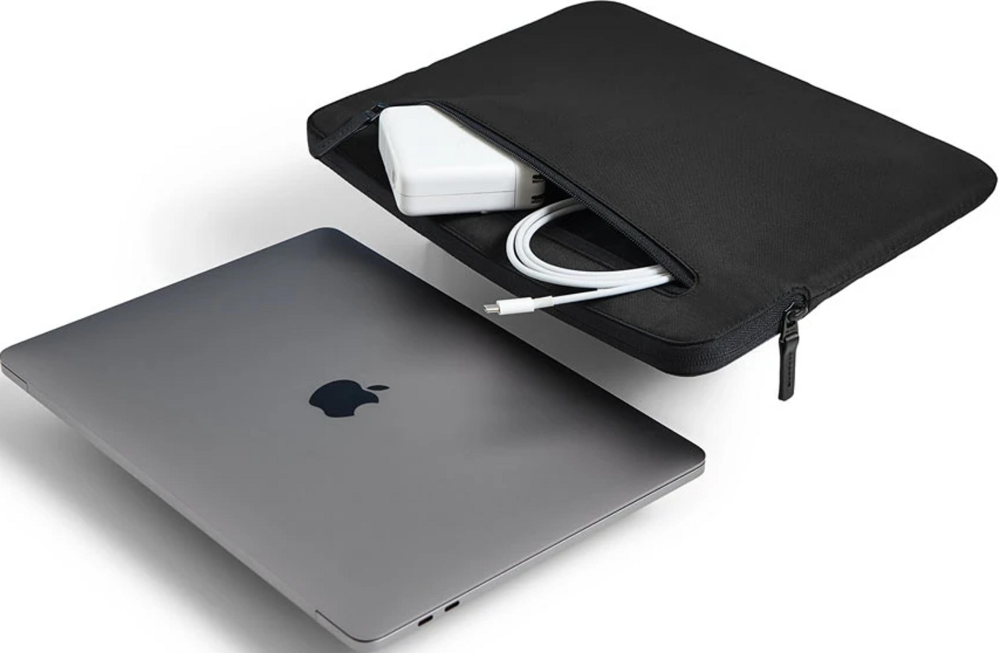 Un MacBook grigio accanto a una custodia nera per laptop con caricabatterie e cavo bianchi.