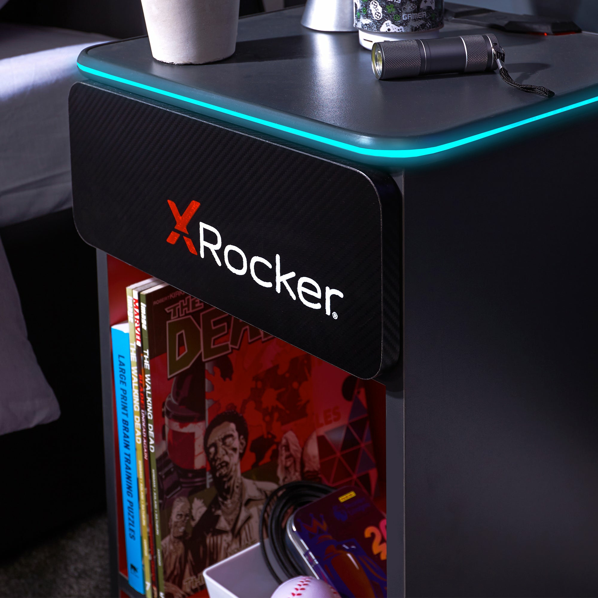 Schwarzer Nachttisch mit blauer LED-Beleuchtung, Comics und einer Taschenlampe.