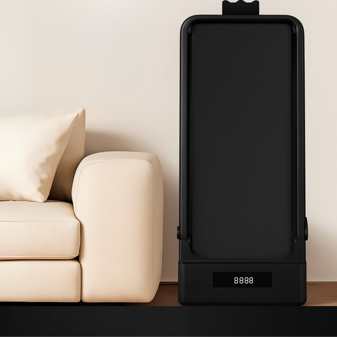 A black treadmill stands beside a cream sofa against a light beige wall.