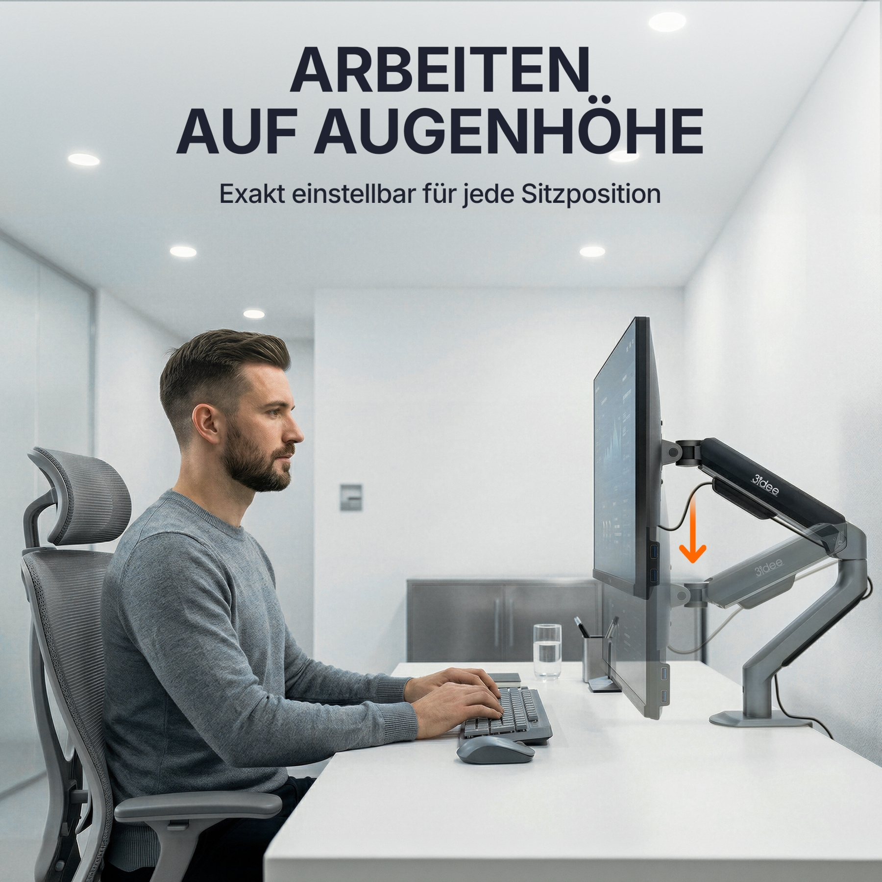 Mann sitzt am Schreibtisch und tippt auf Tastatur, Monitor auf Armhalterung.