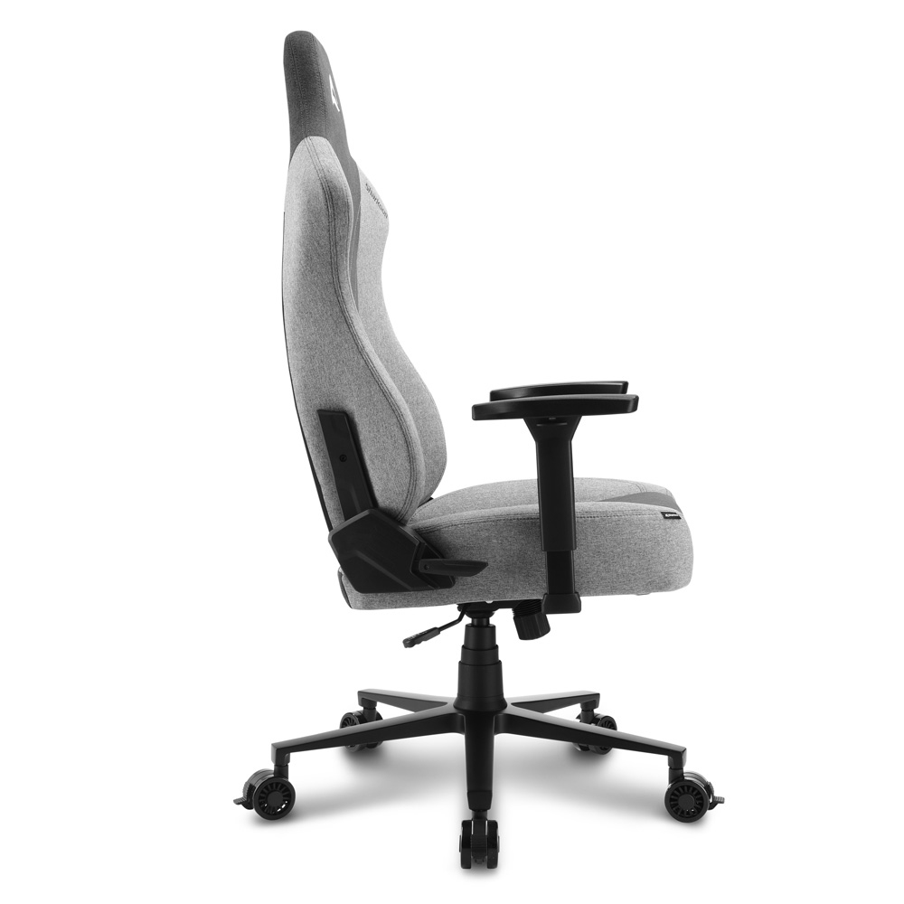 Een grijze gamingstoel van stof met zwarte accenten wordt van opzij getoond tegen een witte achtergrond.