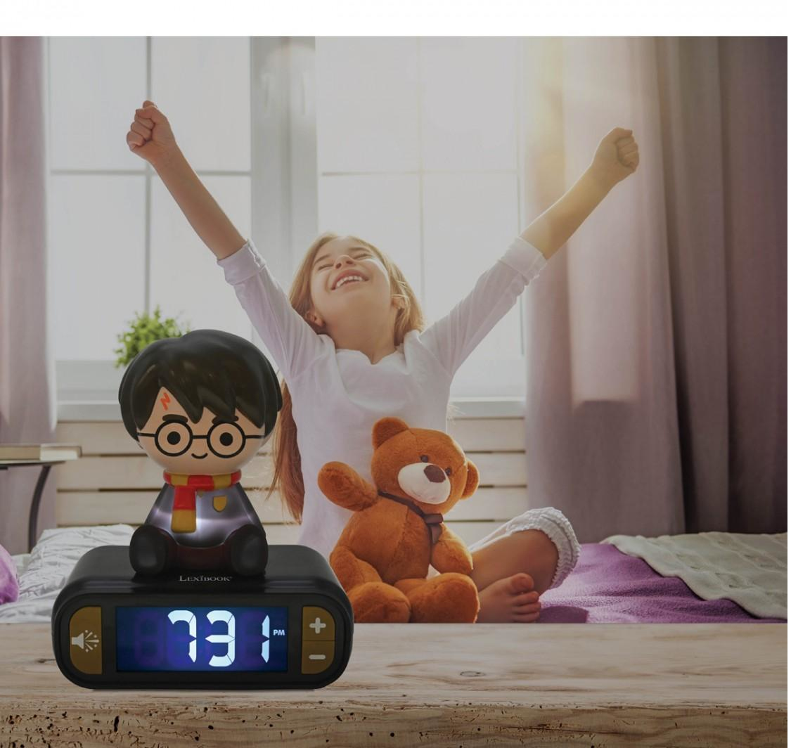Ein Mädchen streckt sich auf dem Bett mit einem Harry Potter Licht und Teddybär neben dem Wecker.