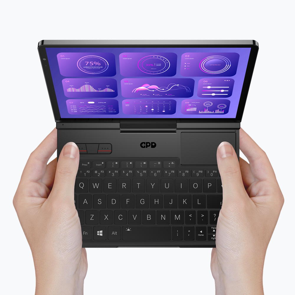 Osoba trzyma mały czarny laptop z otwartym ekranem wyświetlającym wykresy.