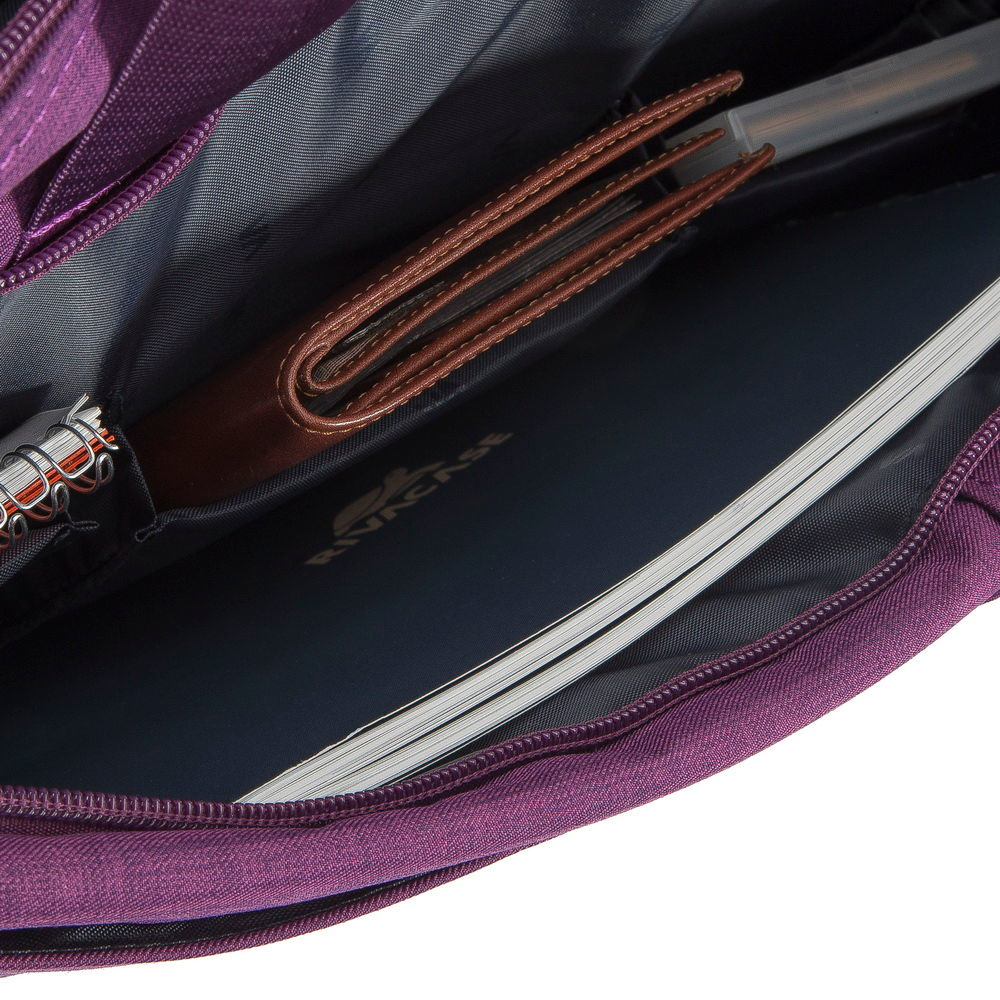Ein braunes Portemonnaie und ein Notizbuch in einer violetten Tasche.