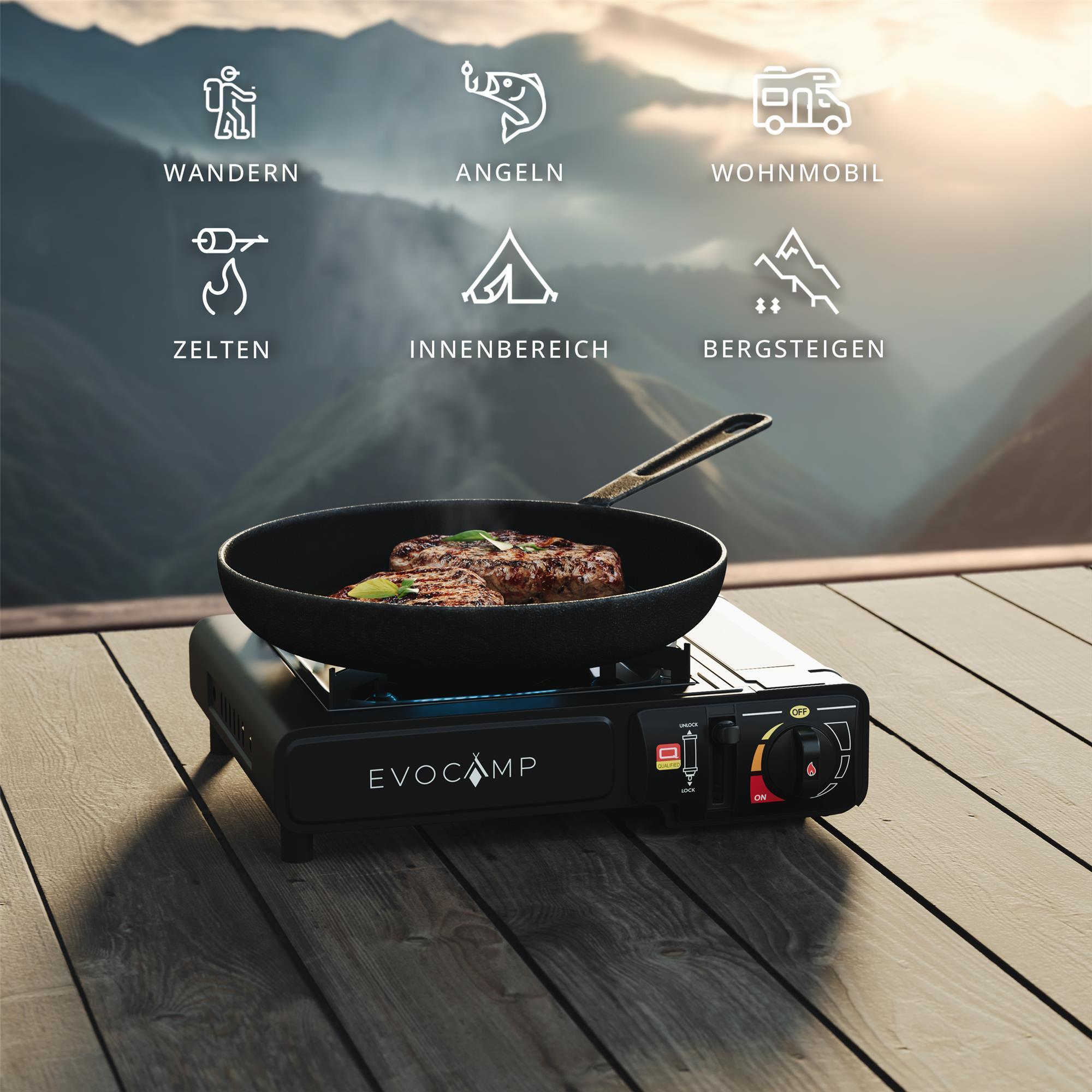 Fleisch brät in einer Pfanne auf einem Campingkocher vor Bergkulisse.