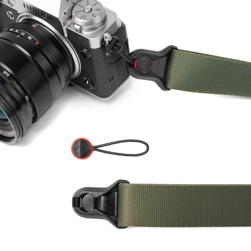 Una fotocamera Fujifilm con cinghia verde Peak Design e collegamenti di ancoraggio.