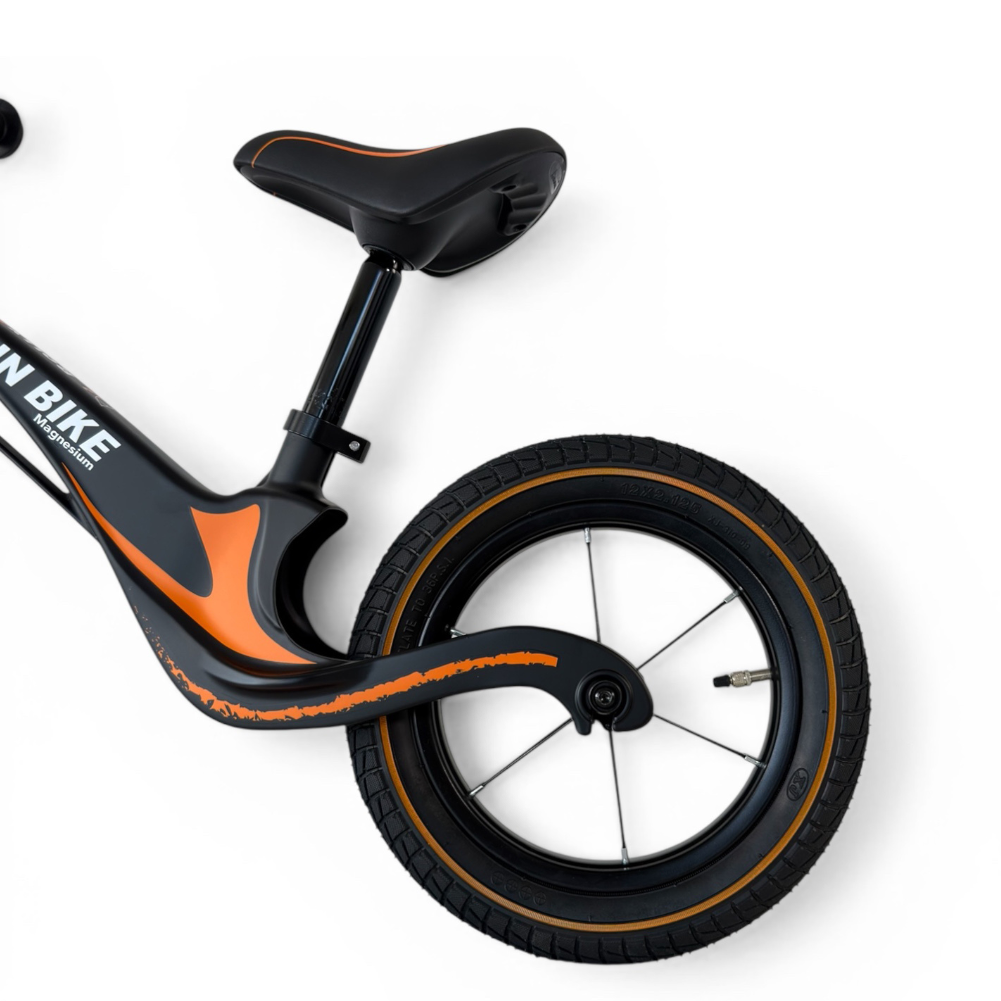 Ein schwarzes und orangefarbenes Kinderrad mit weißem Hintergrund.