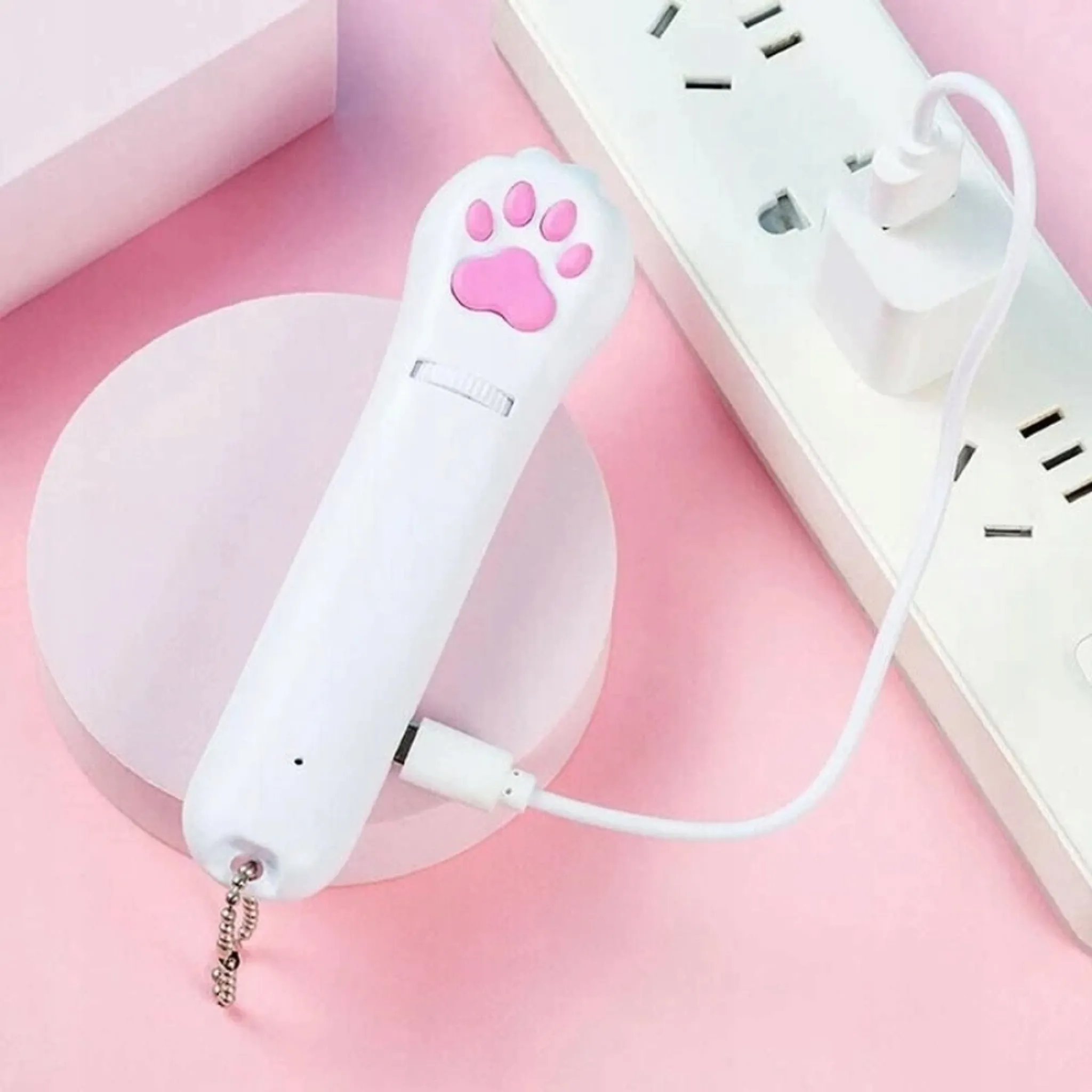 Ein weißer Katzenpfoten-Zeiger mit rosa Zehen wird an ein Ladegerät angeschlossen.