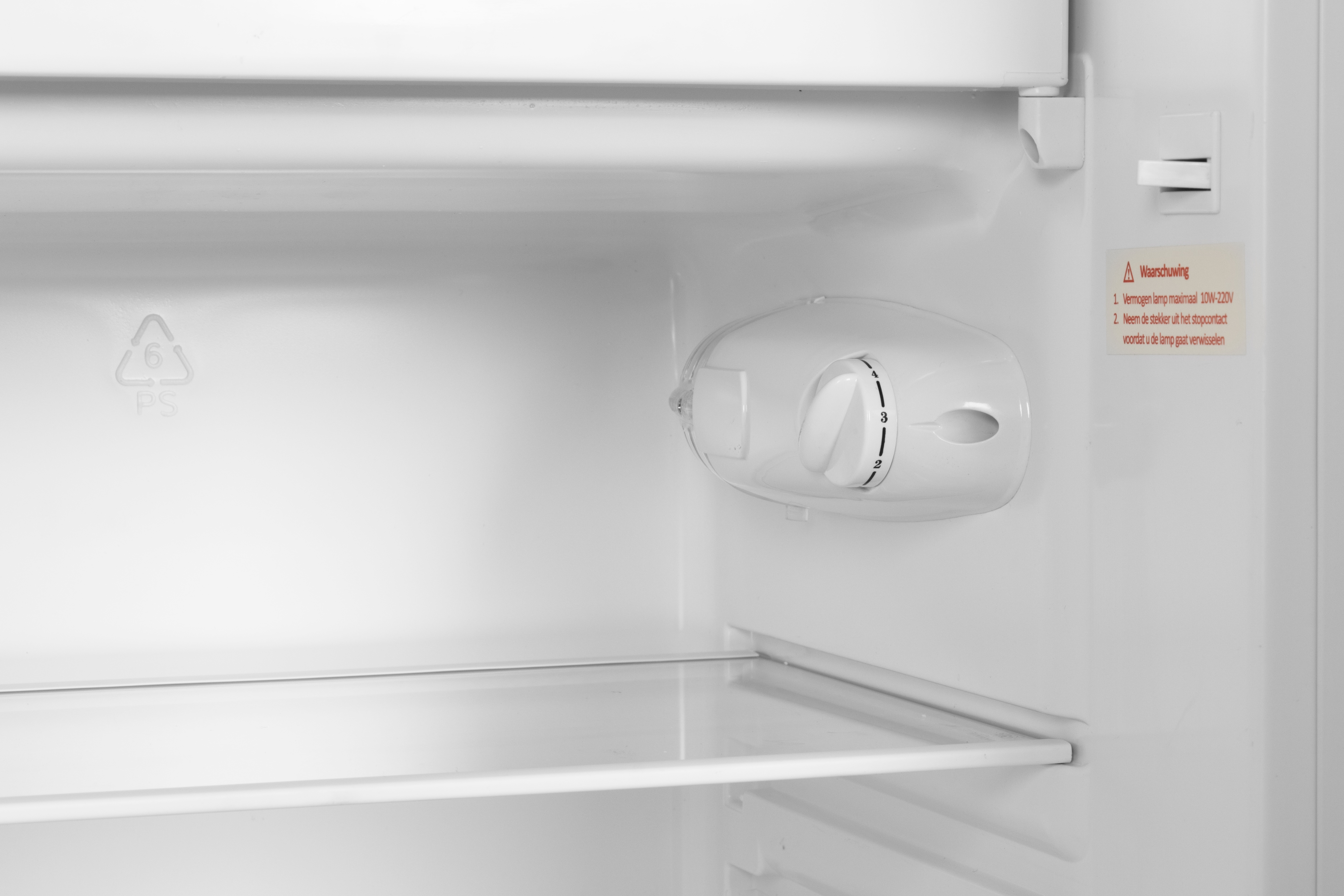 Interior of a refrigerator with a thermostat and warning label.