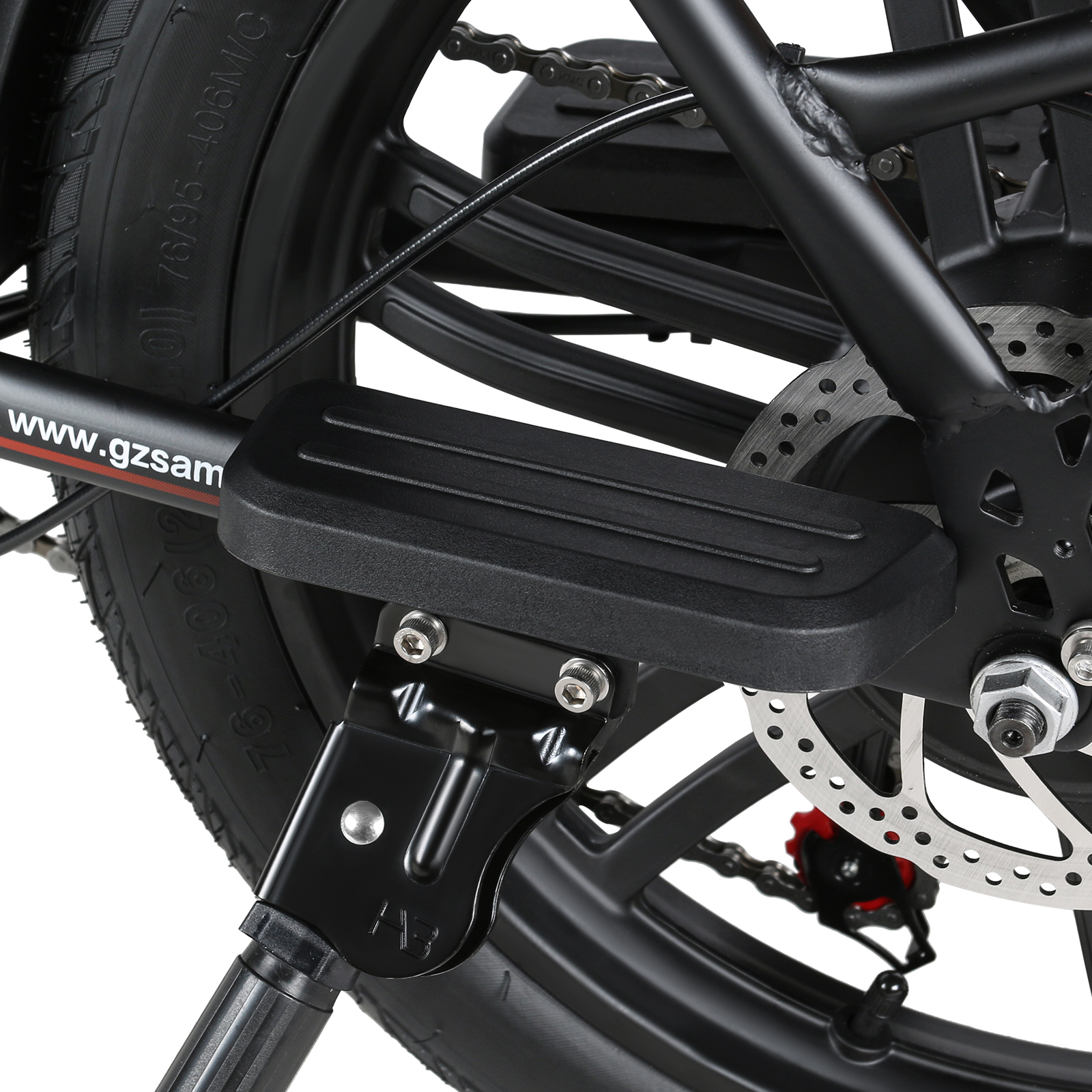 Zbliżenie podnóżka roweru, pokazujące łańcuch, tarczę hamulcową i oponę.