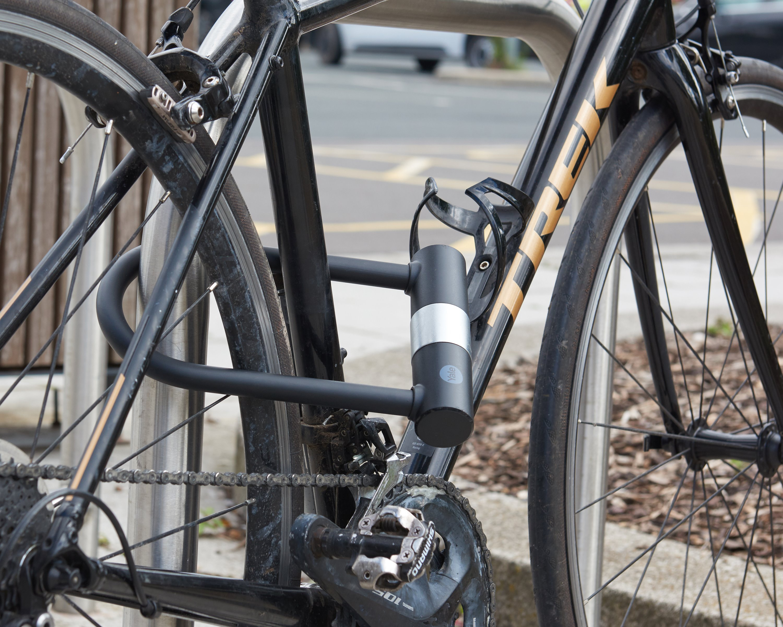 Bicicletta nera con scritte dorate, assicurata con lucchetto a U.