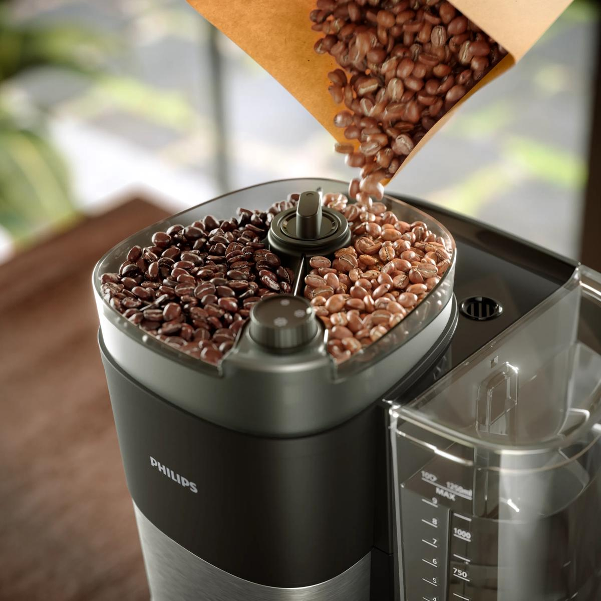 Chicchi di caffè versati da un sacchetto marrone nella tramoggia di un macinacaffè Philips.