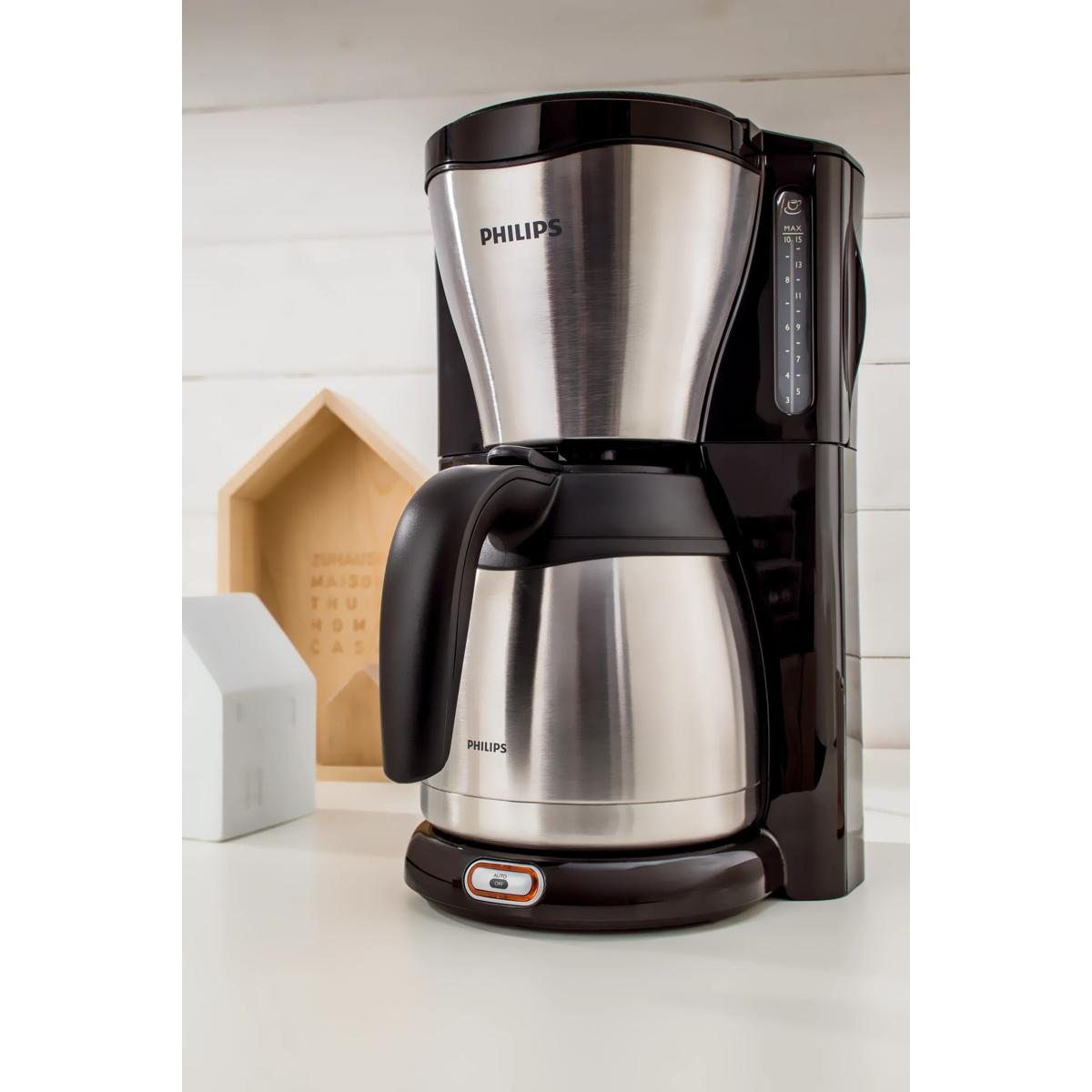 Una caffettiera Philips nera con caraffa termica si trova su un bancone bianco.