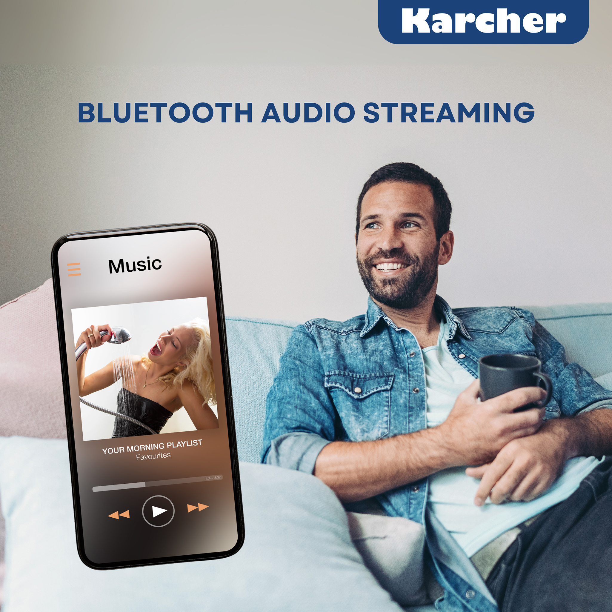 Mann sitzt auf Sofa, hält Tasse, schaut auf Handy mit Musik-App.