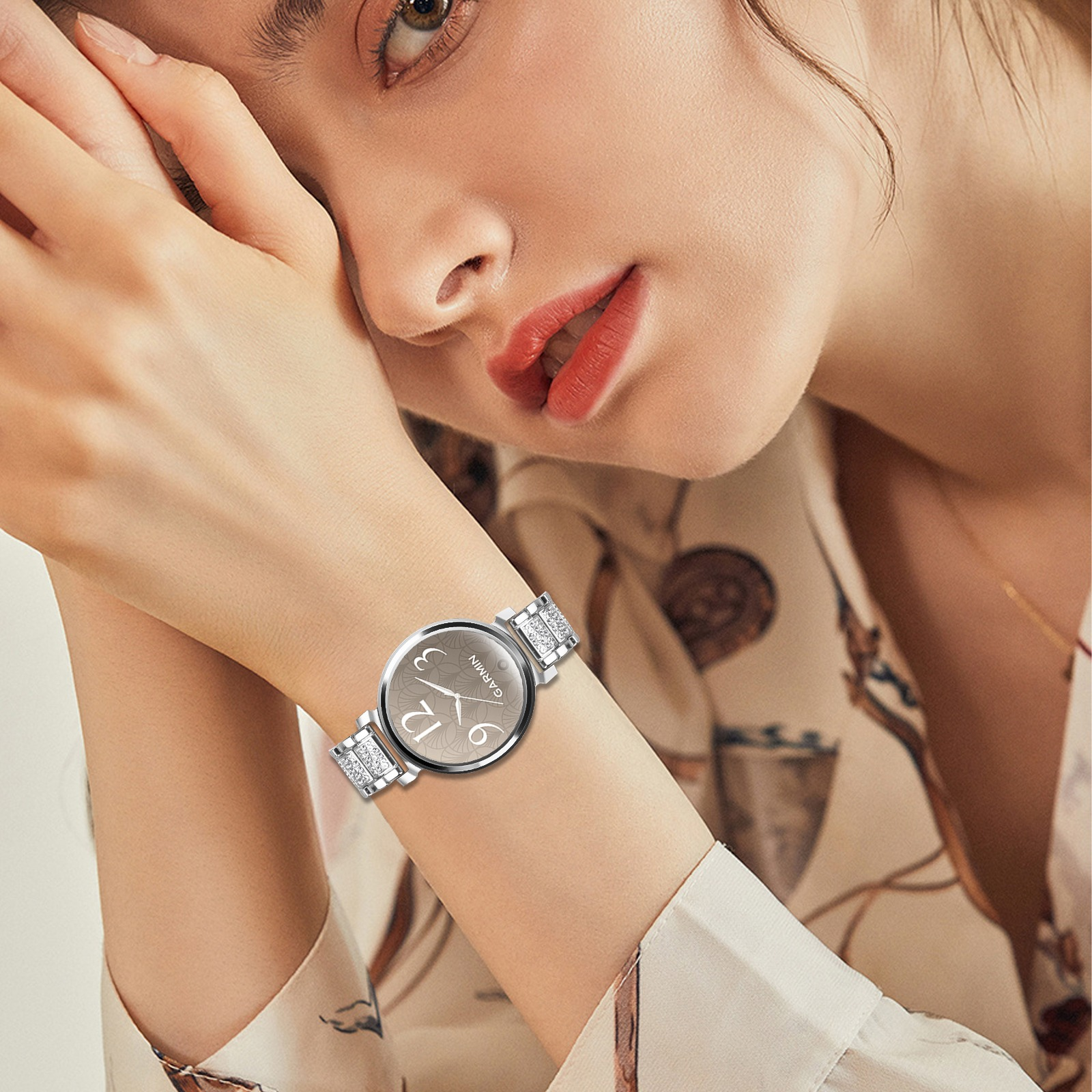 Nahaufnahme einer Frau mit einer silbernen Garmin-Uhr mit glitzerndem Armband.