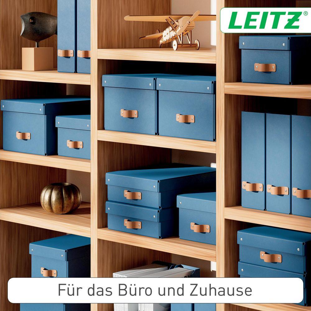 Blaue Aufbewahrungsboxen und Ordner auf Holzregalen, mit kleinem Holzflugzeug und Deko-Kugel.