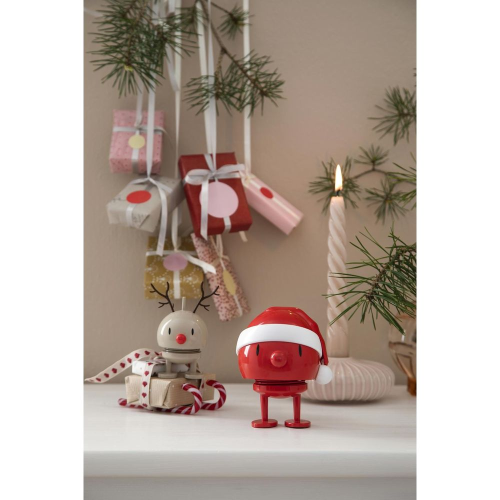 Decorazioni natalizie con regali, figura di renna, figura di Babbo Natale e candela.