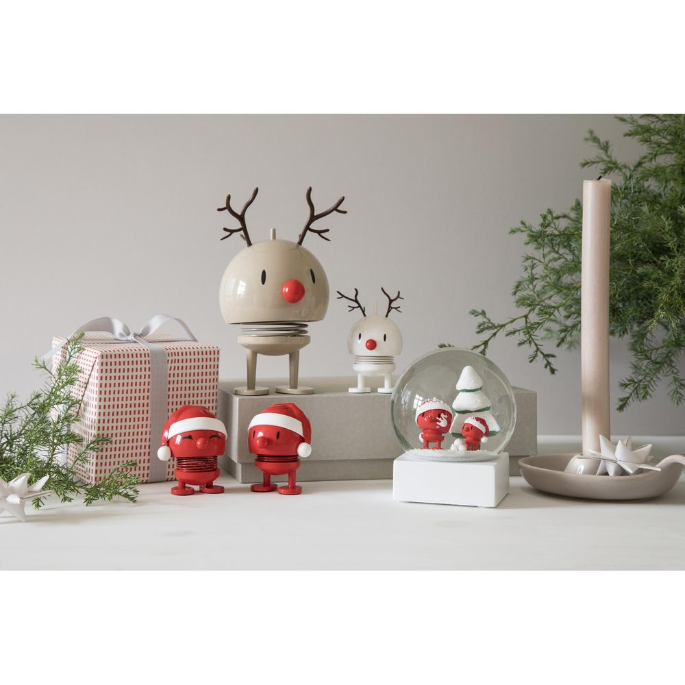Decorazioni natalizie: figure di renne, regali, globo di neve, candela, verde.