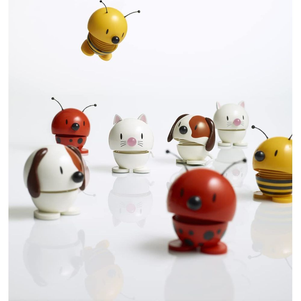 Piccole figure in legno di api, coccinelle, gatti e cani su sfondo bianco.