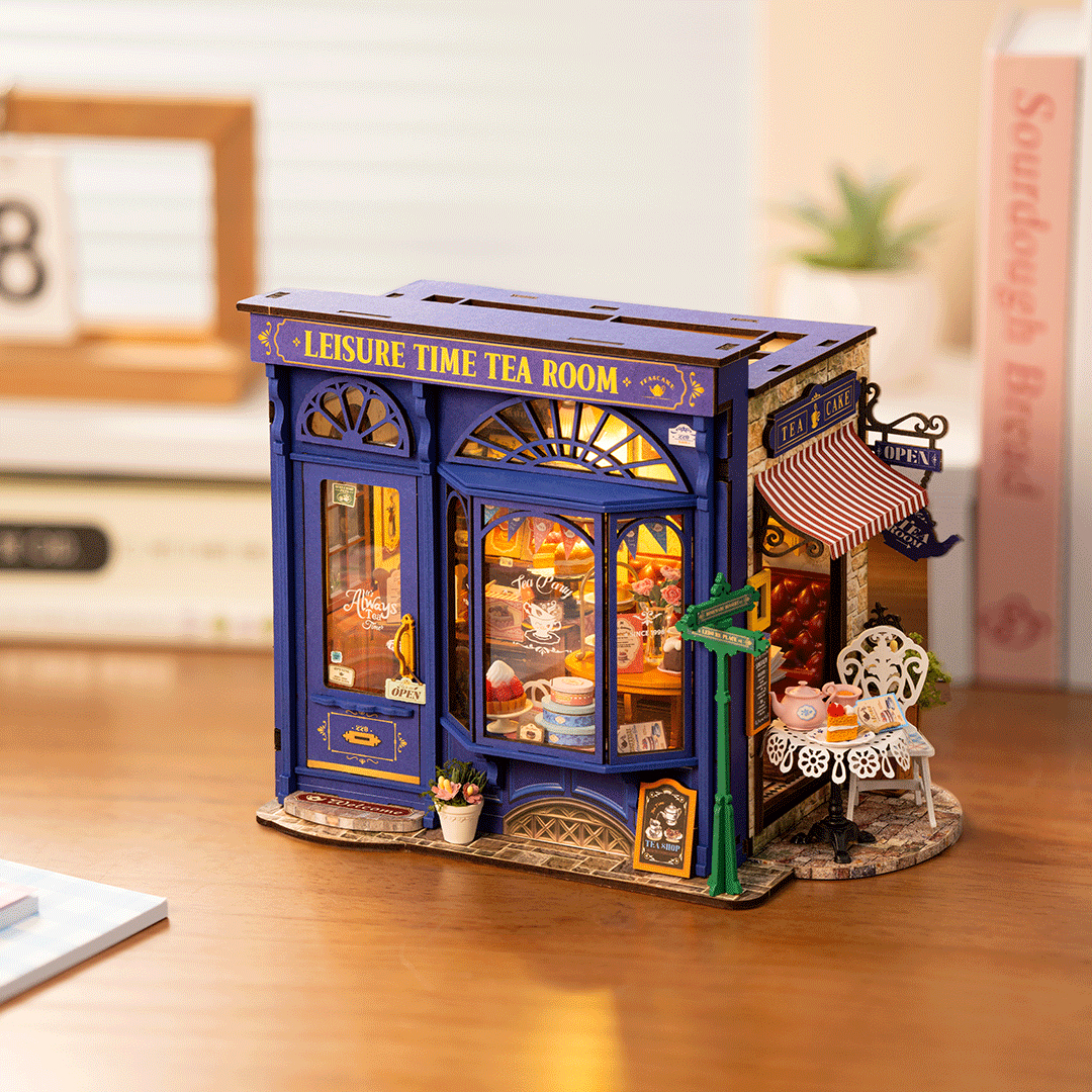 Ein Miniatur-Teeladen mit blauen Fassaden, Schildern und Tischen im Freien.