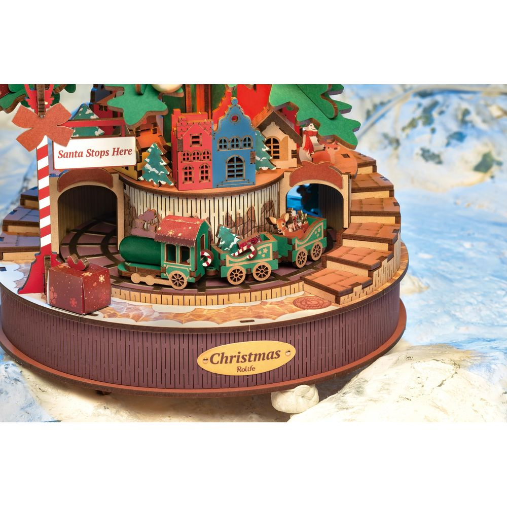 Ein Weihnachts-Diorama mit einem Zug, Häusern und einem "Santa Stops Here"-Schild.