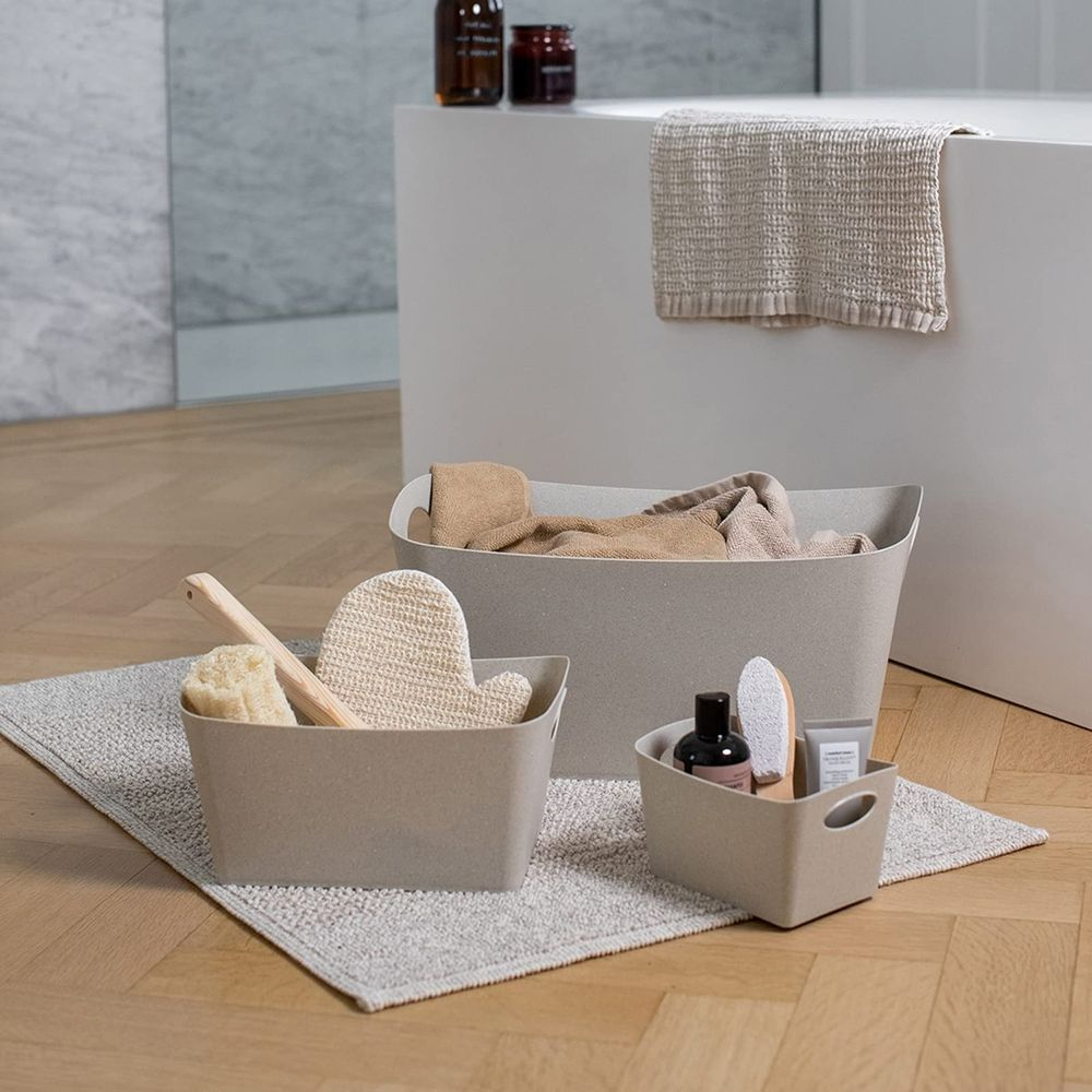 Drei beige Körbe mit Badutensilien auf einem Teppich.