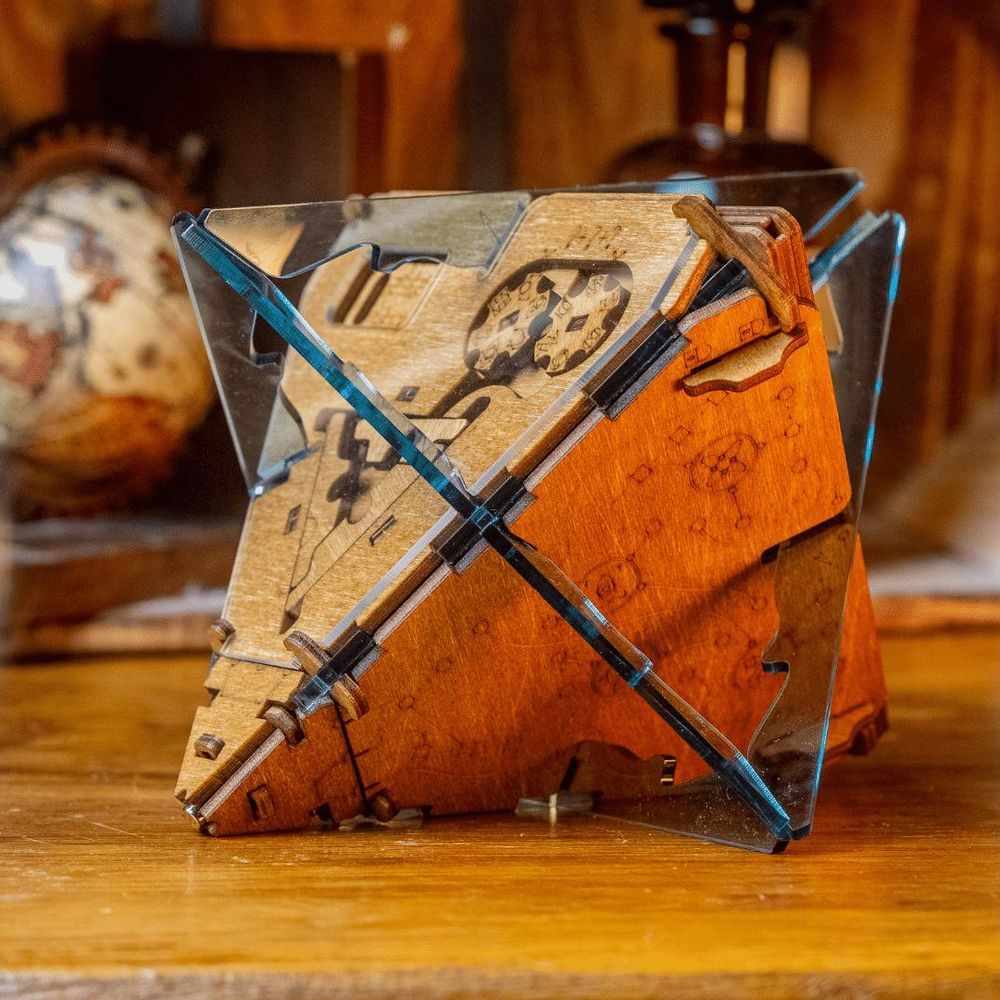 Un cubo puzzle in legno con accenti metallici su una superficie di legno.