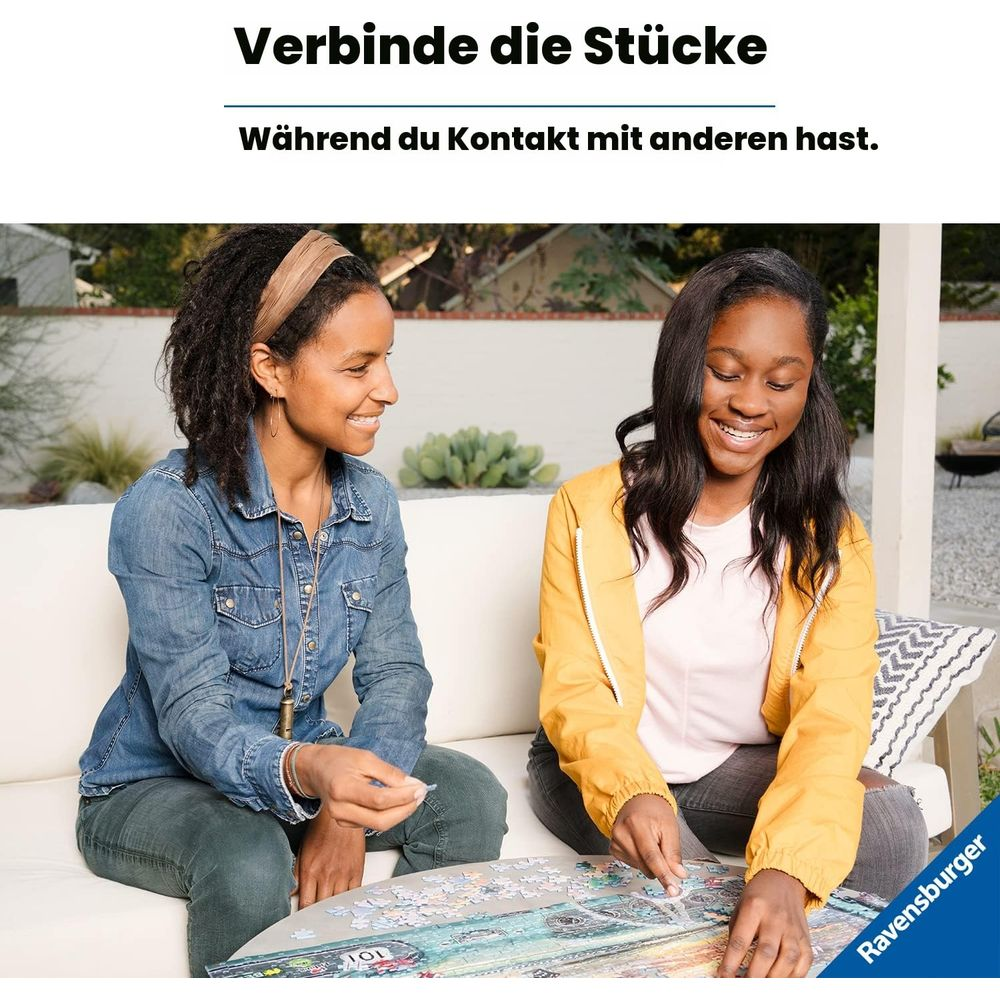 Due donne sedute su un divano giocano a un puzzle all'aperto.