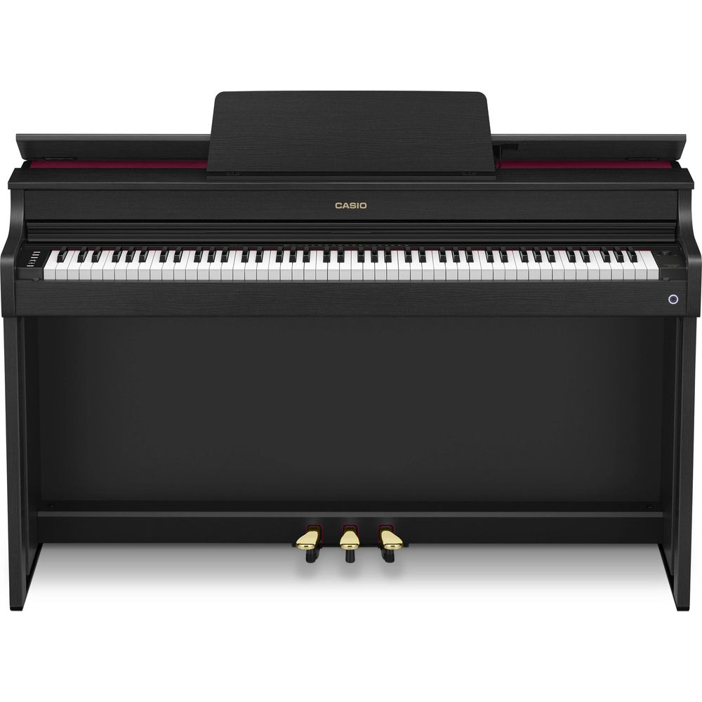 Un piano numérique noir avec clavier blanc et trois pédales.
