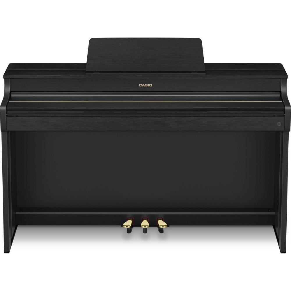 Un piano numérique droit noir avec pupitre et trois pédales.