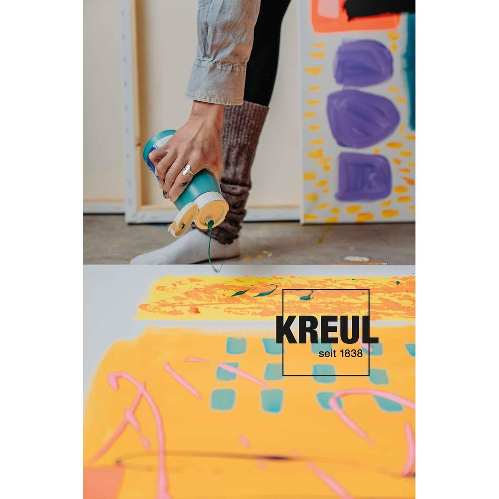 Eine Hand drückt grüne Farbe aus einer Flasche auf eine gelbe Leinwand. Kunst im Hintergrund.