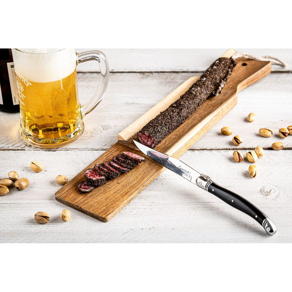 Aufgeschnittene und ganze Wurst auf Holzbrettern mit Bier und Pistazien.