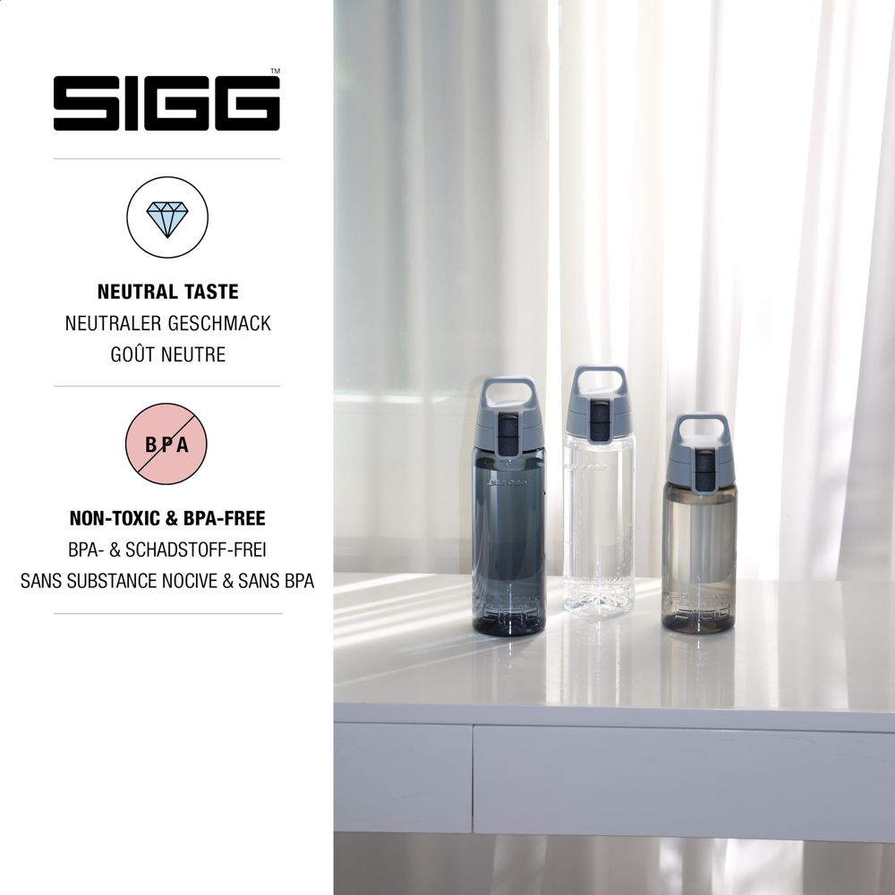 Drei SIGG-Trinkflaschen auf einem Tisch, zwei dunkelgrau, eine klar. Links ist Werbung.