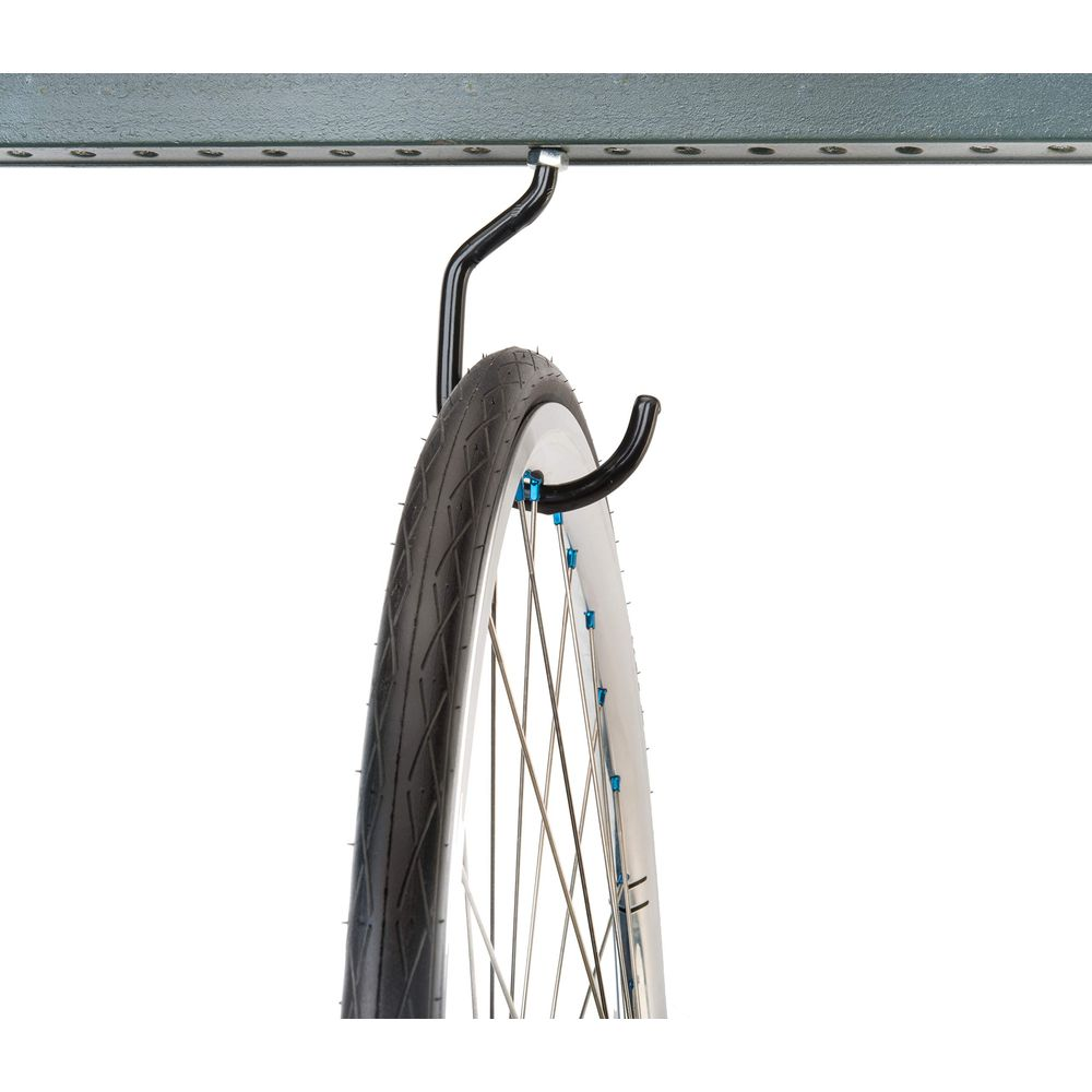 Ein Fahrradreifen hängt an einem Haken unter einer Metallstange.
