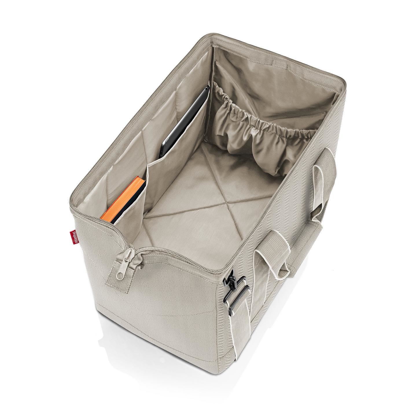 Offene beige Stofftasche mit gepolsterten Fächern, die ein Tablet und Buch enthält.