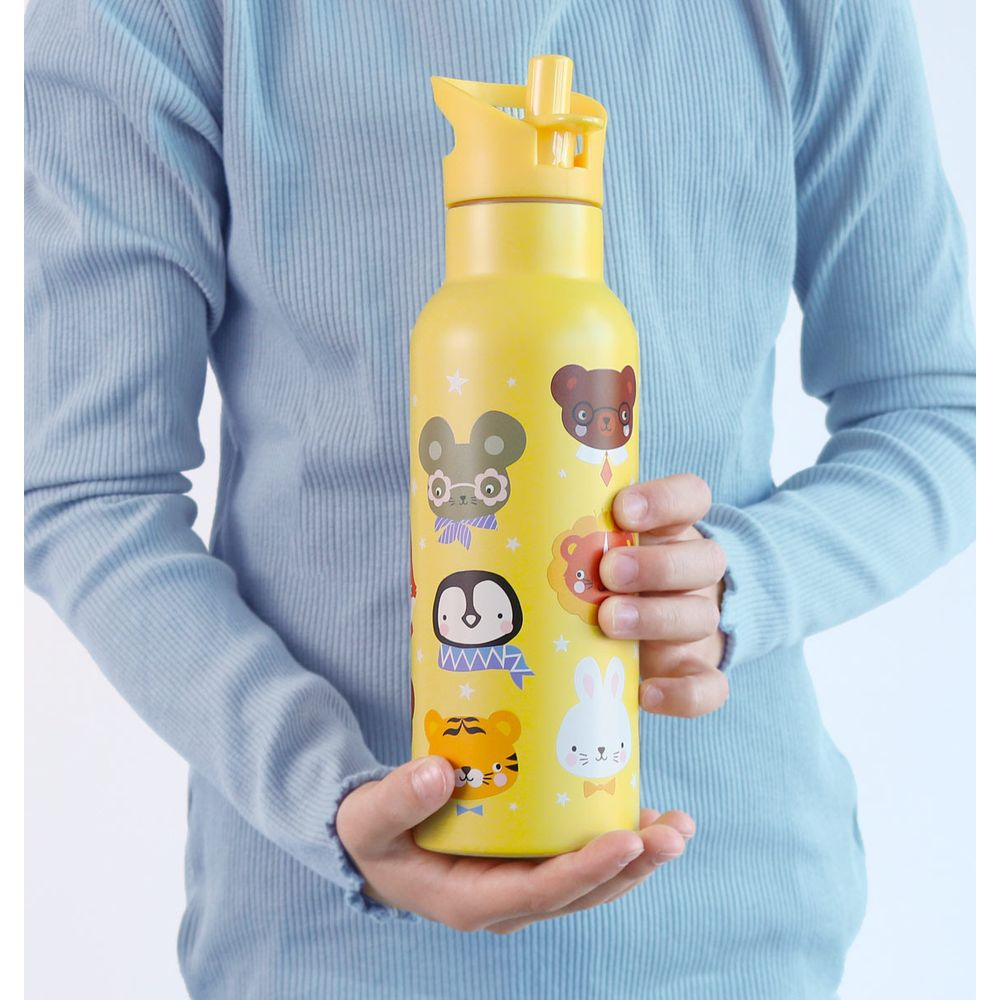 Ein gelber Becher mit Tiermotiven, der von Händen gehalten wird.