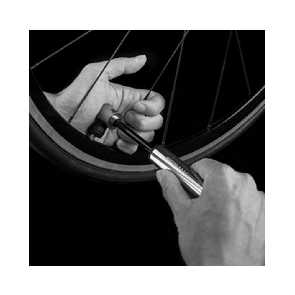 Hände benutzen eine Fahrradpumpe, um einen Reifen aufzupumpen.