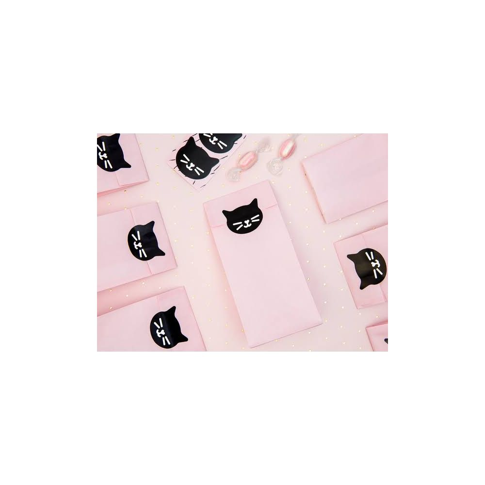 Rosa Geschenktüten mit süßen Katzenaufklebern und Bonbons auf einem funkelnden Hintergrund.