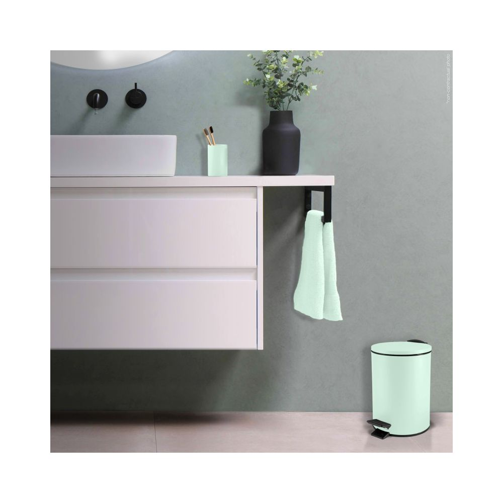Badezimmereinrichtung mit Waschbecken, Schubladen, Handtuchhalter, Mülleimer und Vase.